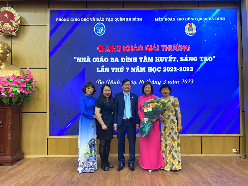 A group of people posing for a photo in front of a large blue banner

Description automatically generated with medium confidence