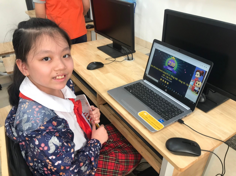 A young child sitting at a desk with a computer

Description automatically generated with low confidence