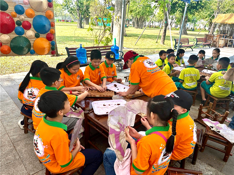 A group of children sitting around a table

Description automatically generated