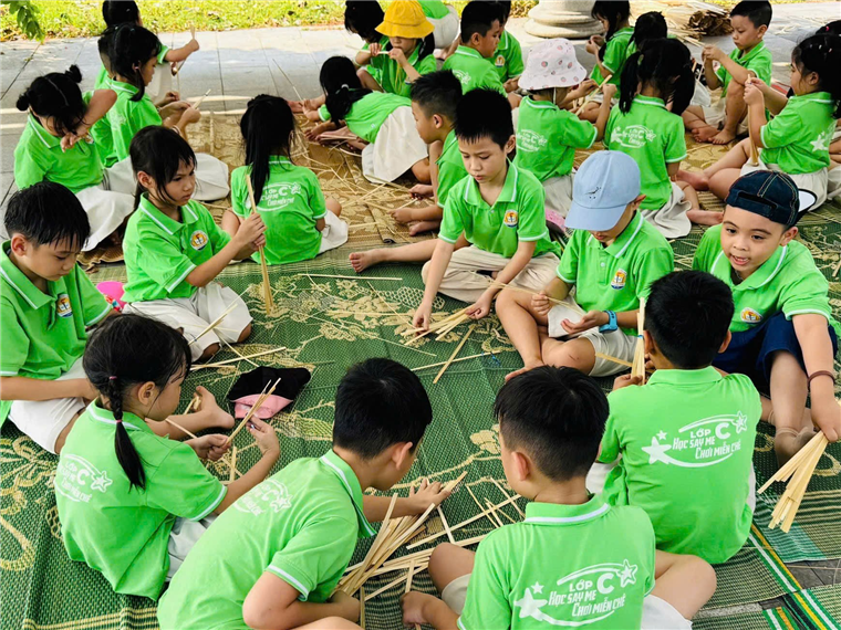A group of children in green shirts sitting on a floor

Description automatically generated