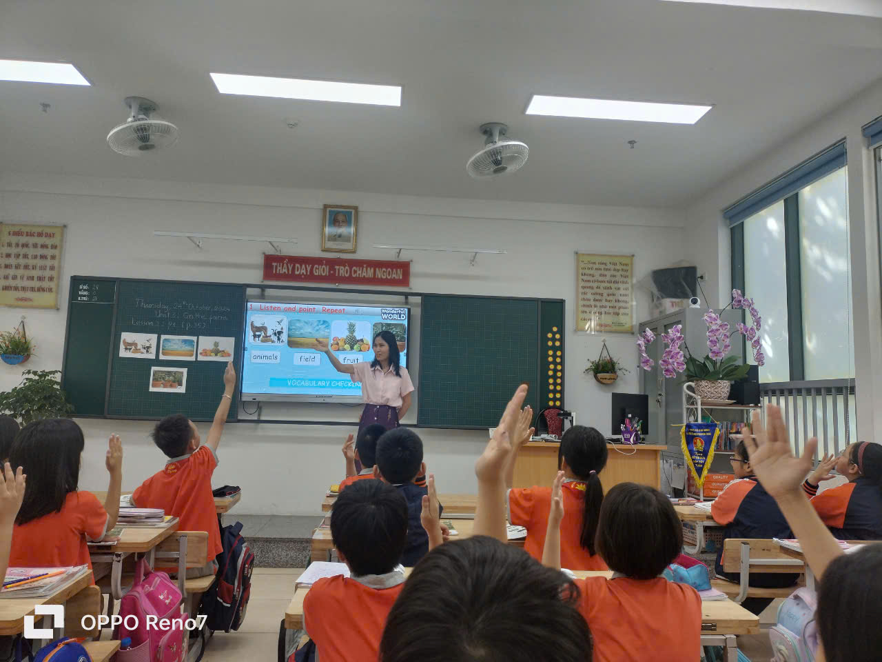 A group of children raising their hands in a classroom

Description automatically generated