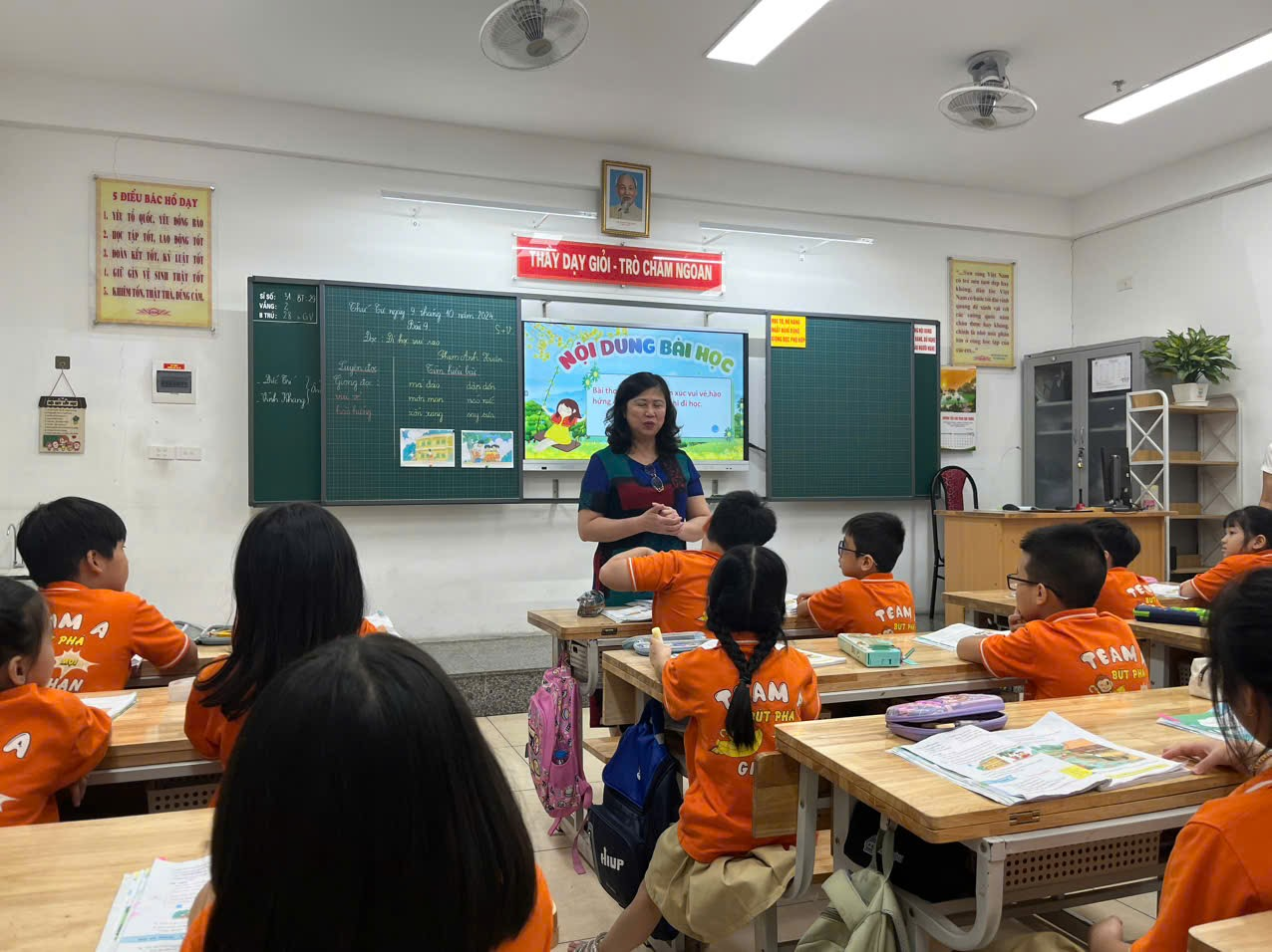 A person teaching a group of children in a classroom

Description automatically generated