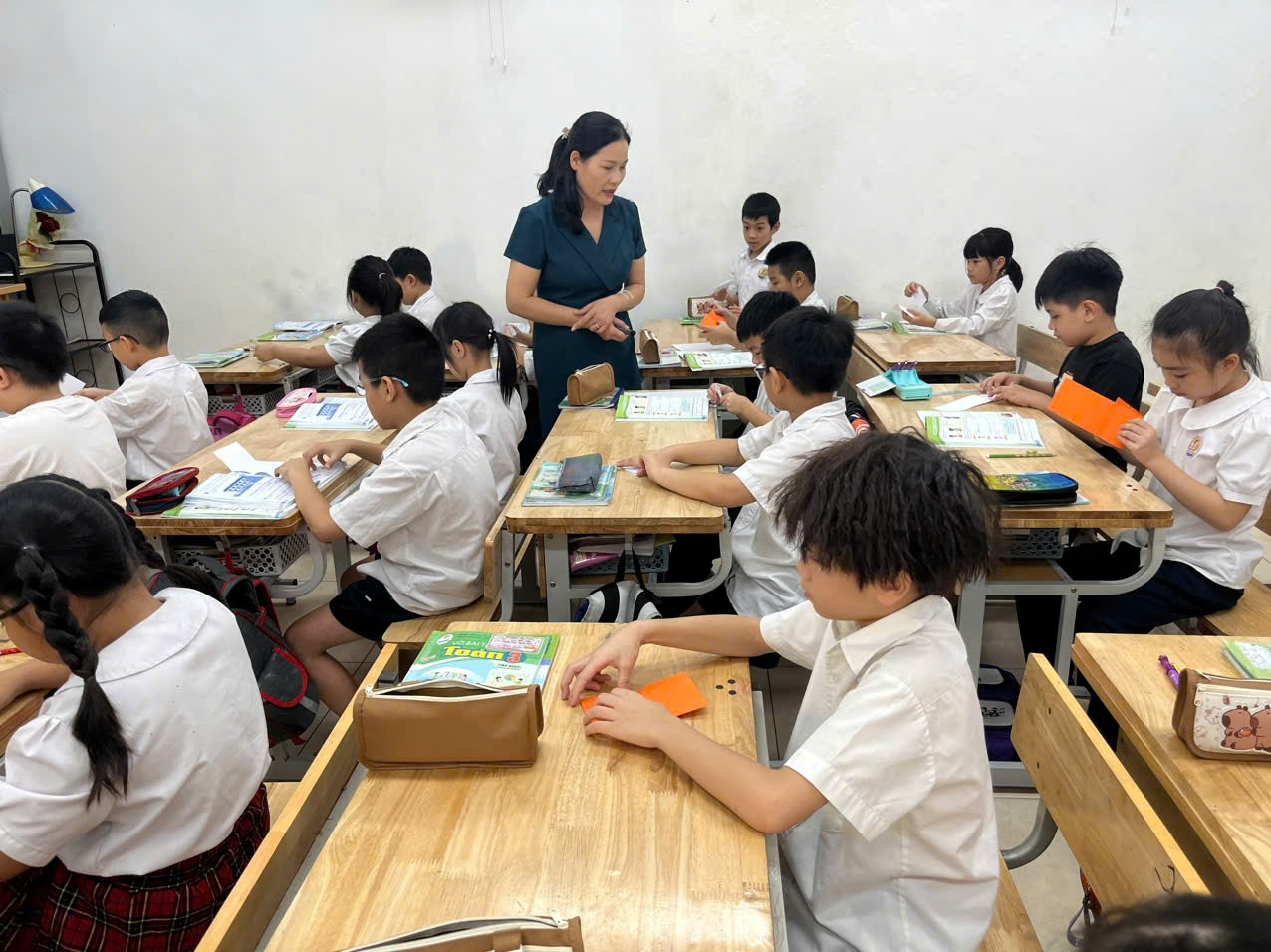 A teacher standing next to a group of students

Description automatically generated