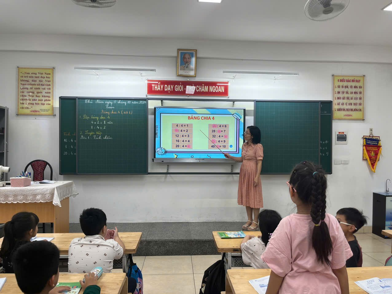 A person standing in front of a screen in a classroom

Description automatically generated