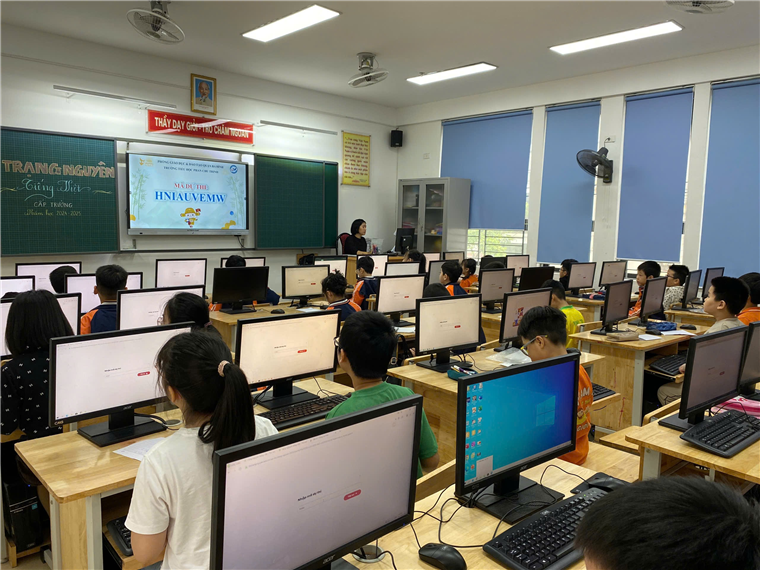 A group of people in a classroom with computers

Description automatically generated