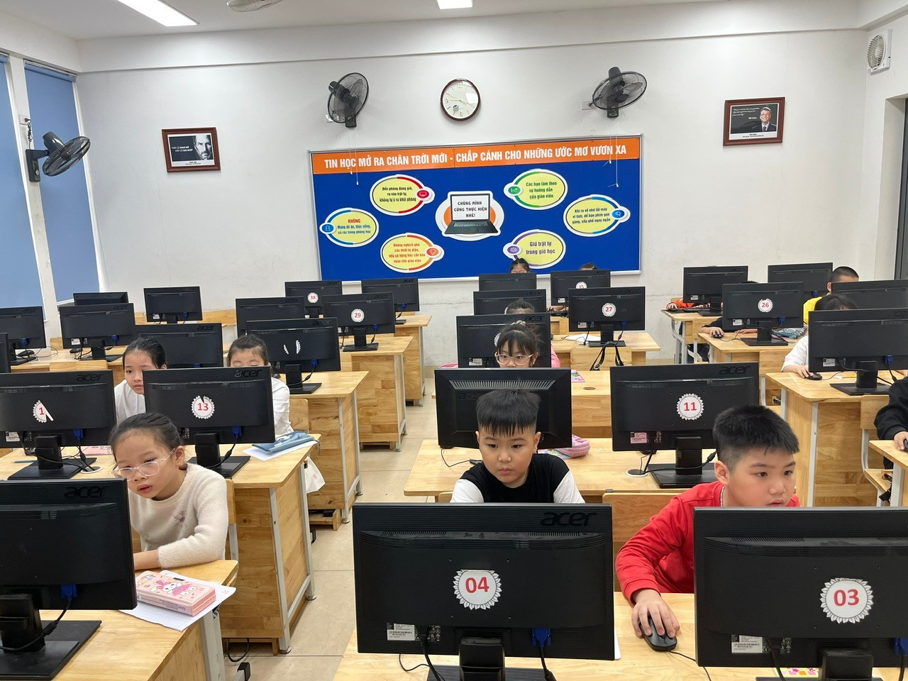 A group of kids sitting at computers

Description automatically generated
