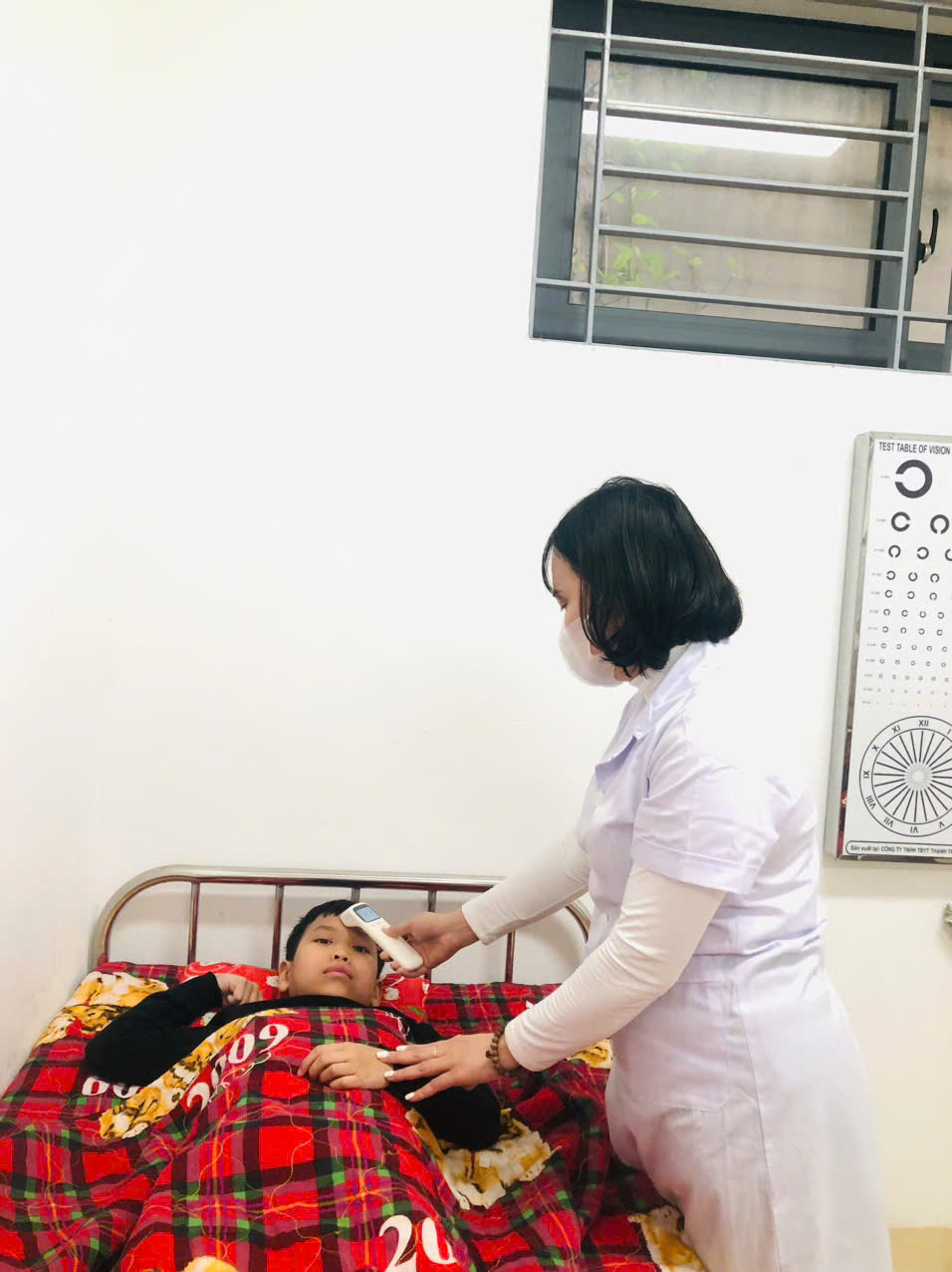 A person in a white coat measuring a child's temperature

AI-generated content may be incorrect.