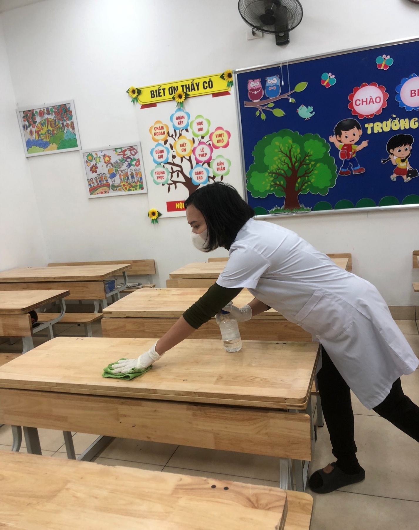 A person wearing a white coat and gloves cleaning a desk

AI-generated content may be incorrect.
