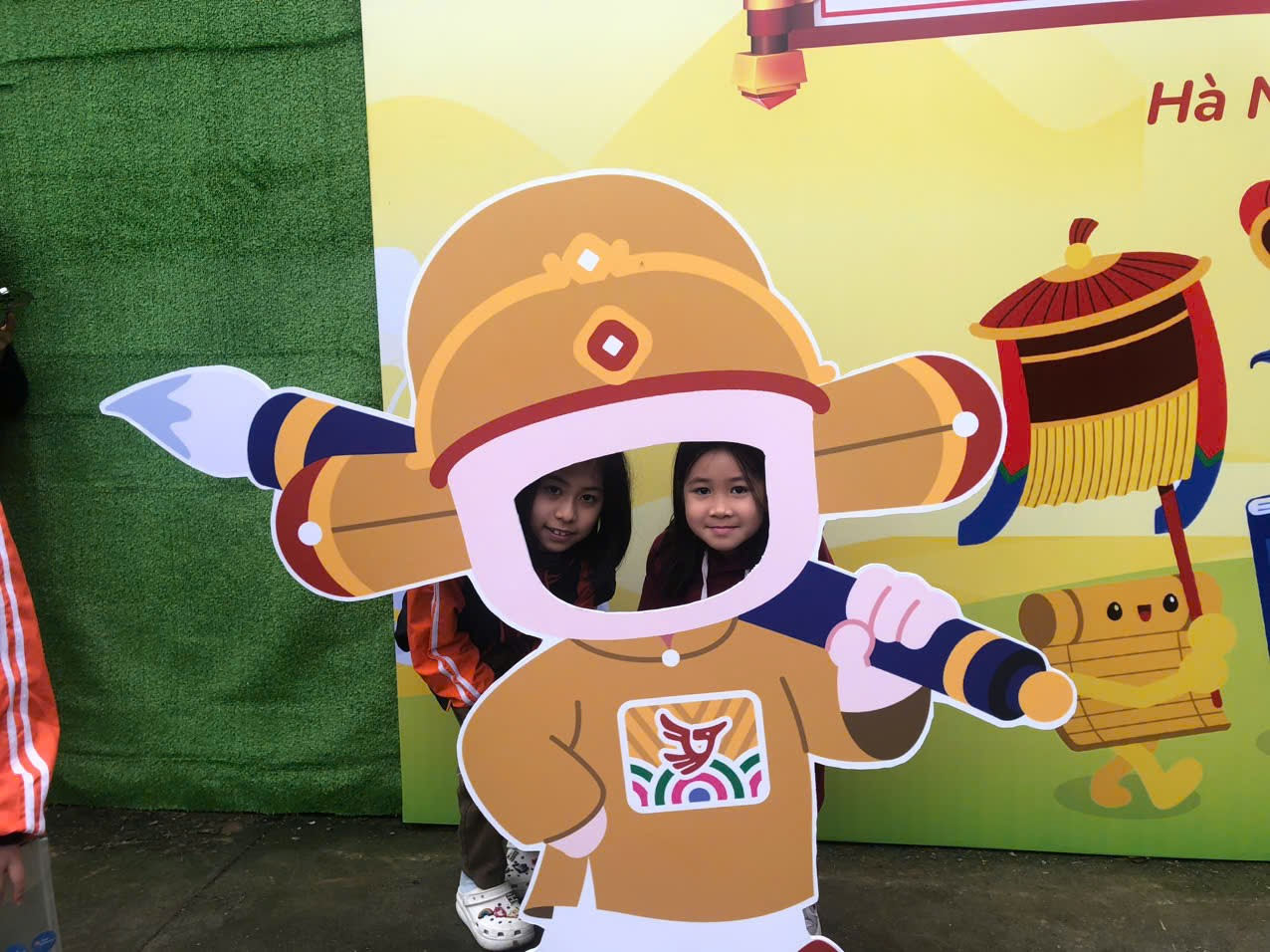 Two girls standing next to a cutout of a cartoon character

AI-generated content may be incorrect.