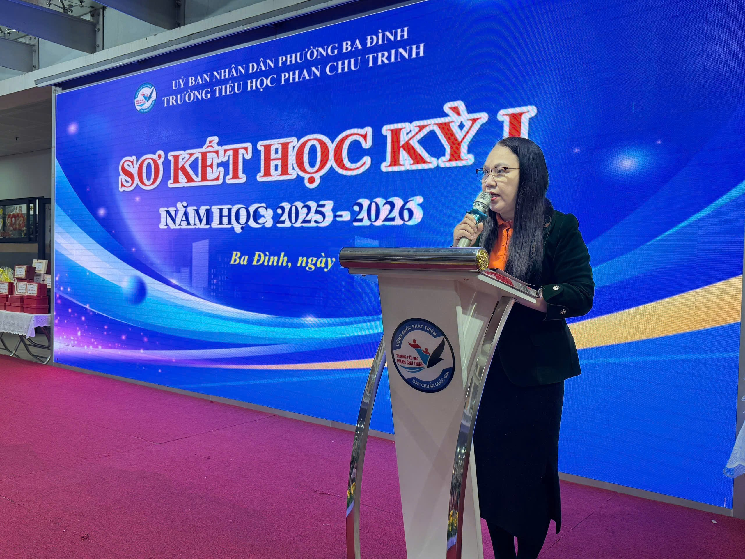 A person standing at a podium speaking into a microphone

AI-generated content may be incorrect.